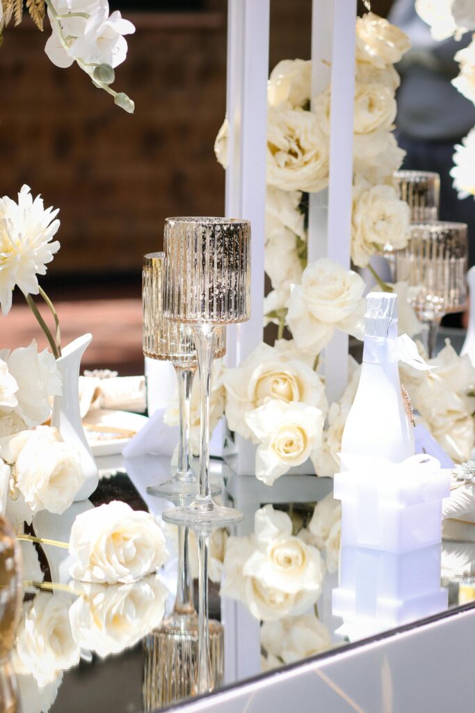 Beautiful outdoor table setup with white flowers and glassware, perfect for elegant events.